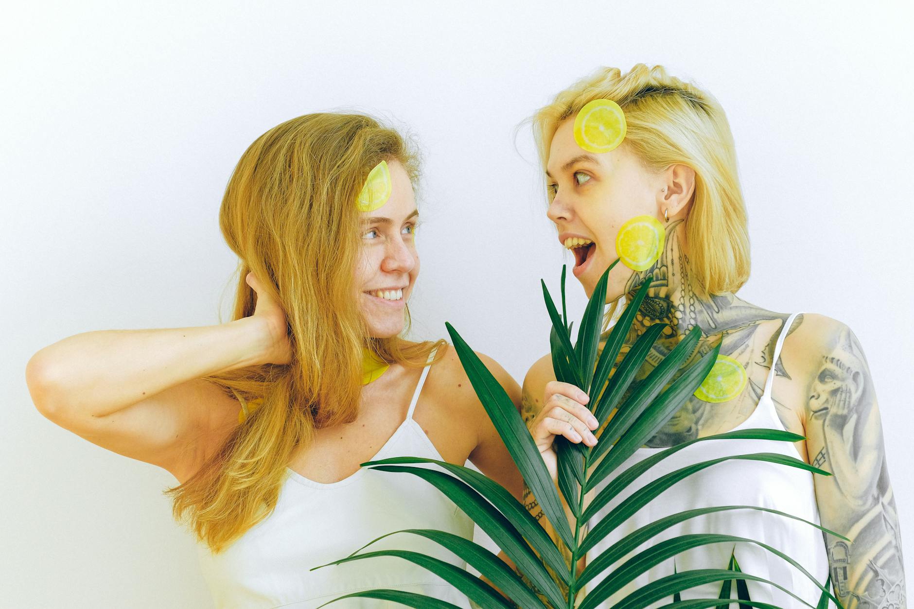 Two people smiling with tropical plants, expressing joy and connection indoors